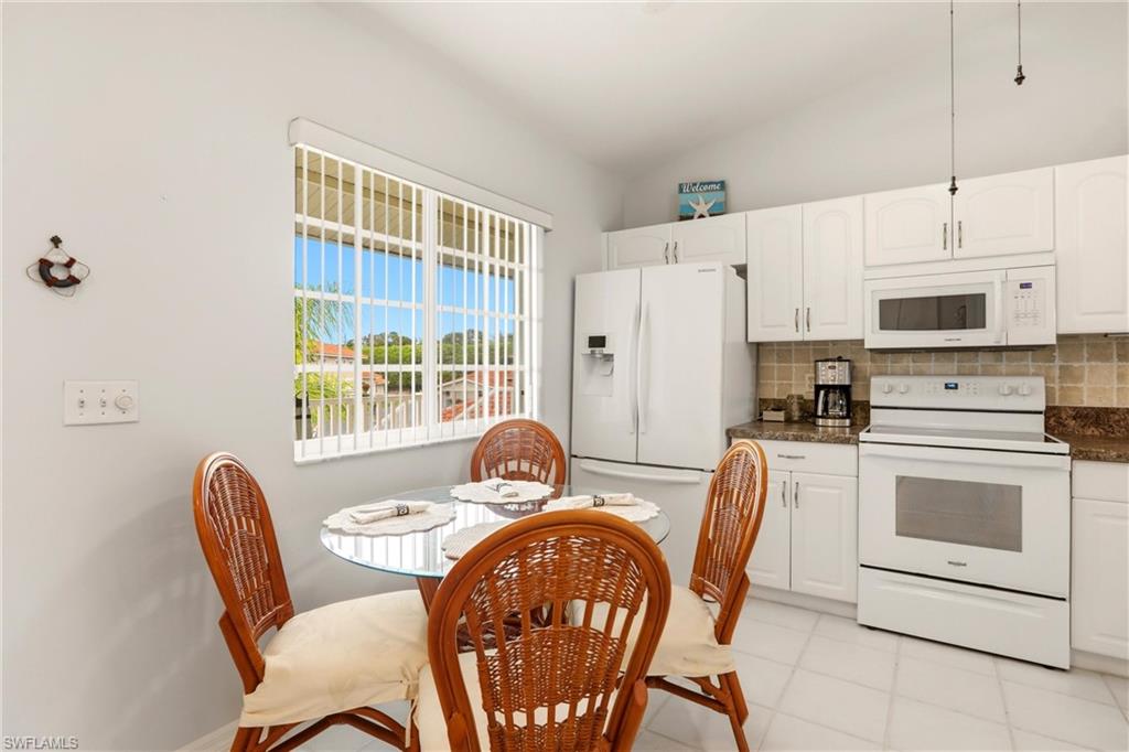 1723 Reuven Circle, Unit 2004 Naples, FL 34112 - Photo 2 of 29 a dining room with furniture a window and a kitchen view