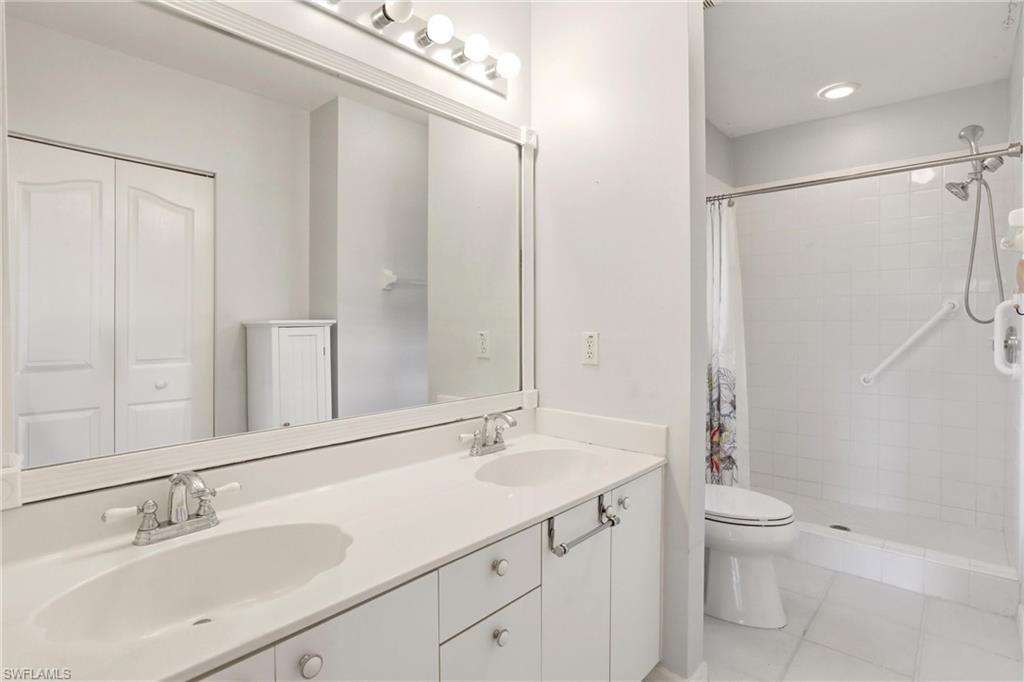 1723 Reuven Circle, Unit 2004 Naples, FL 34112 - Photo 22 of 29 a bathroom with a granite countertop sink a toilet and shower