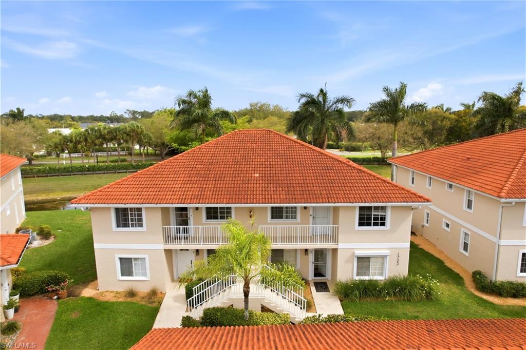 1723 Reuven Circle, Unit 2004 Naples, FL 34112 - Photo 27 of 29 a front view of a house with a yard