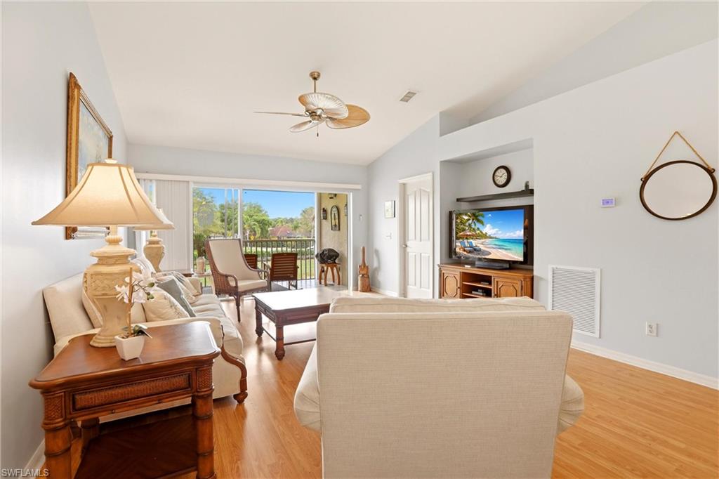 1723 Reuven Circle, Unit 2004 Naples, FL 34112 - Photo 4 of 29 a living room with furniture a flat screen tv and a large window