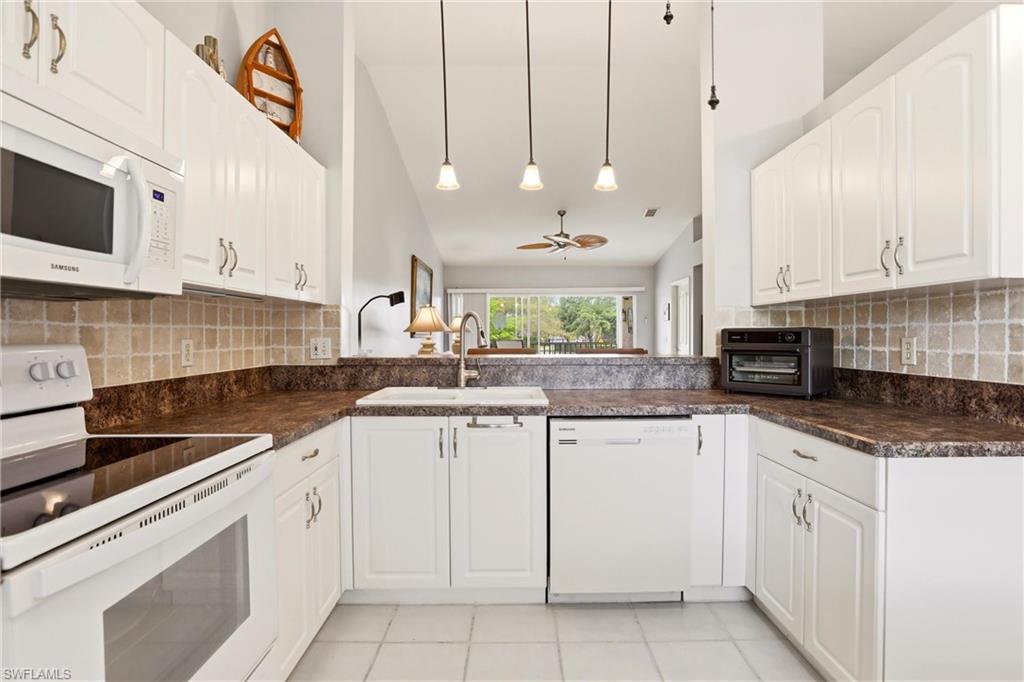 1723 Reuven Circle, Unit 2004 Naples, FL 34112 - Photo 8 of 29 a kitchen with white cabinets and appliances