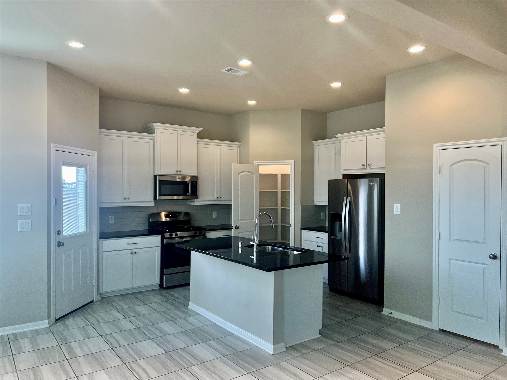 5255 Prairie Terrace Lane Fulshear, TX 77441 - Photo 4 of 28 Kitchen with glass backsplash and granite counters! Fridge stays.