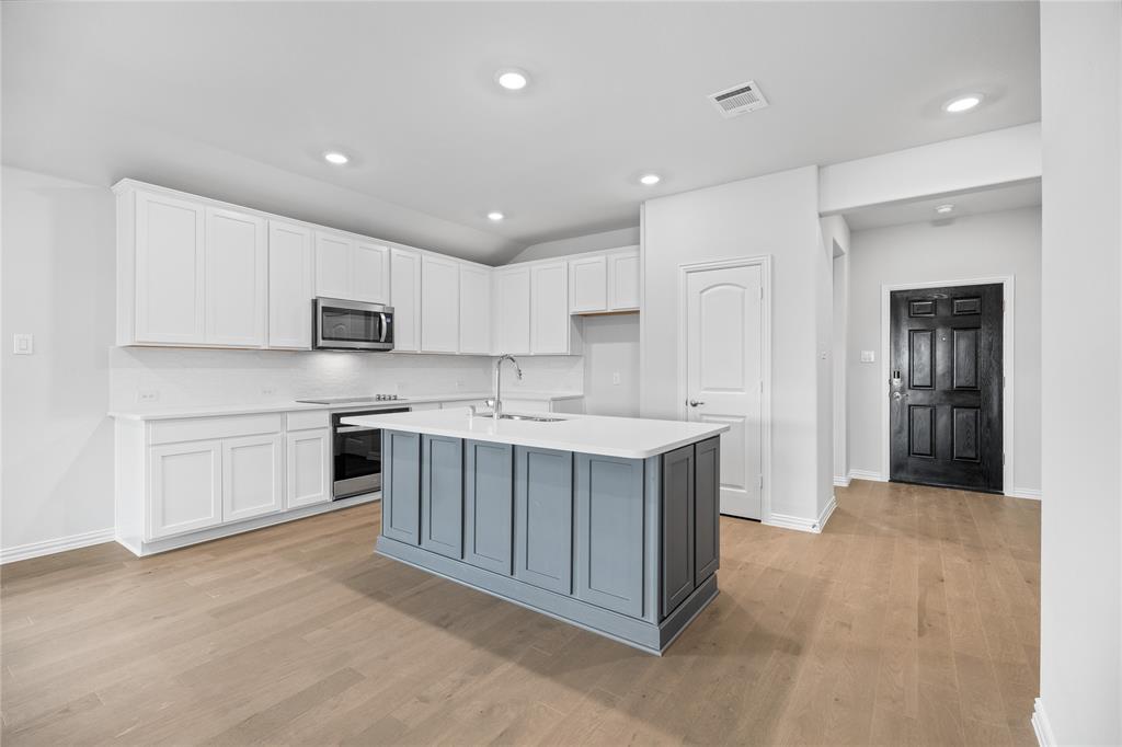 2608 Freeman Street Anna, TX 75409 - Photo 13 of 22 a kitchen with white cabinets stainless steel appliances and a sink