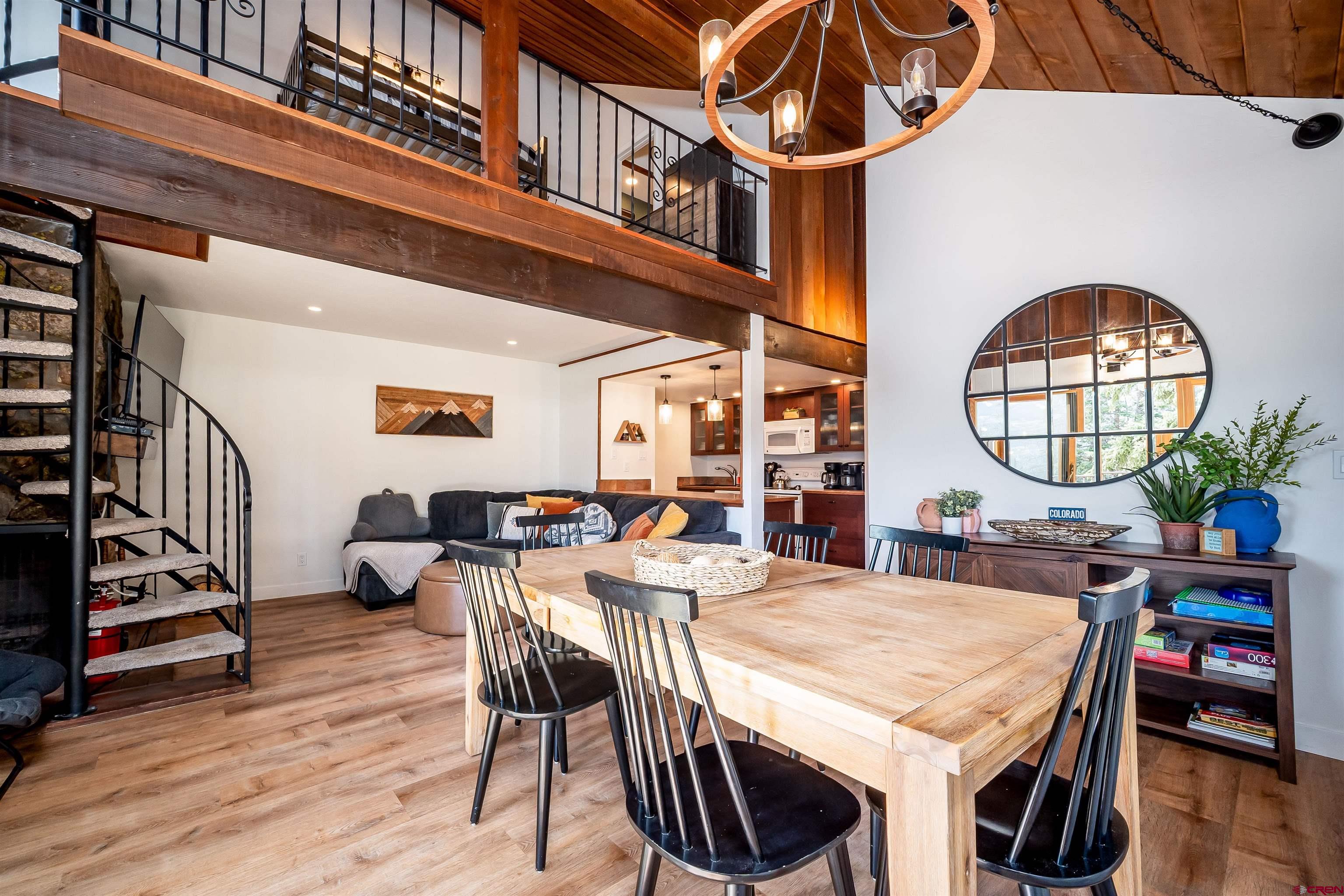44 Sheol Street, Unit A22 Durango, CO 81301 - Photo 8 of 34 a view of a dining room and livingroom with furniture wooden floor a rug and a chandelier