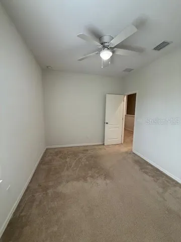an empty room with a fan and a ceiling fan