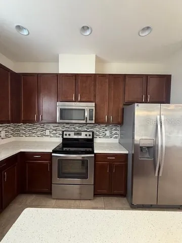 a kitchen with wooden cabinets and stainless steel appliances