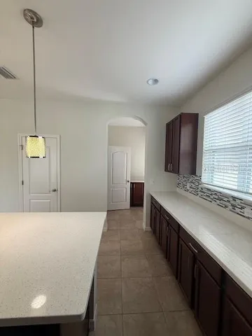 a large kitchen with kitchen island a sink stainless steel appliances and window