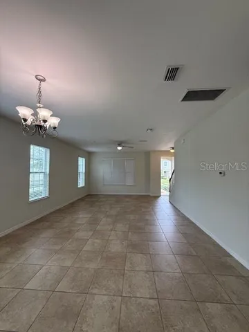 a view of a livingroom with a chandelier fan and windows