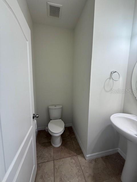 7231 Shadeview Alley Windermere, FL 34786 - Photo 9 of 22 a white toilet sitting next to a white sink and vanity