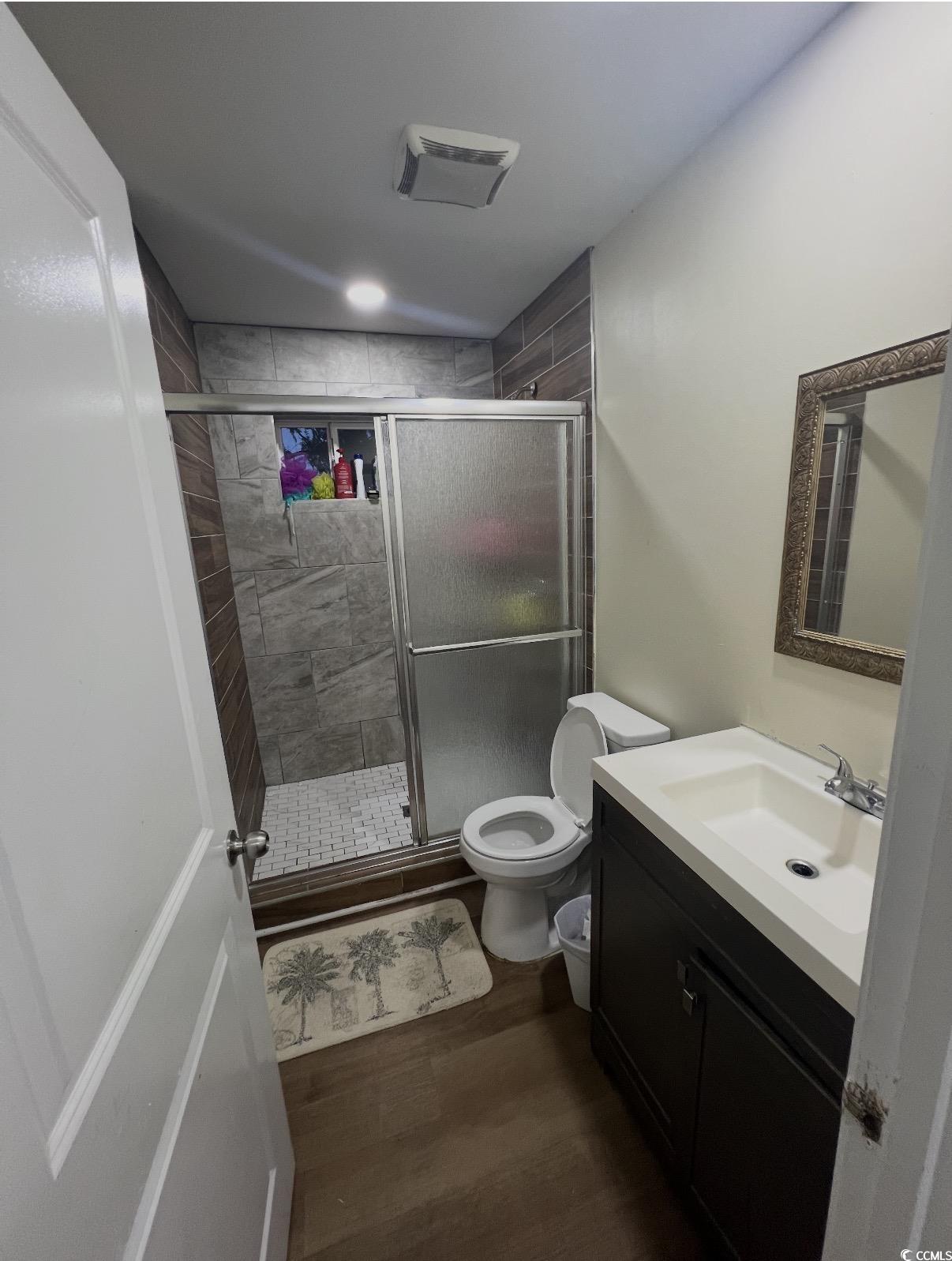 3840 Ed Smith Avenue Myrtle Beach, SC 29588 - Photo 11 of 11 Full bathroom with vanity, dark wood-style flooring, and a shower stall