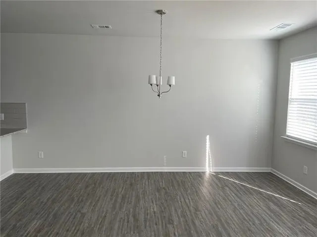 a view of a room with wooden floor and windows