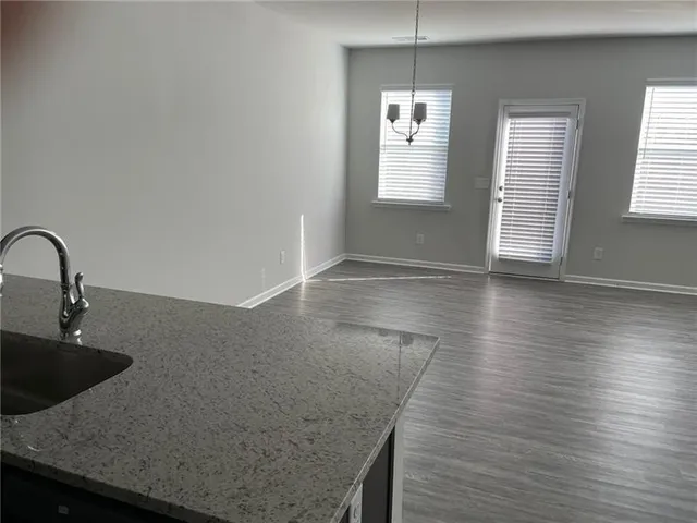 a kitchen with granite countertop a sink a stove and wooden floor