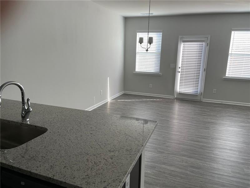 92 Shelter Lane East Dawsonville, GA 30534 - Photo 6 of 19 a kitchen with granite countertop a sink a stove and wooden floor