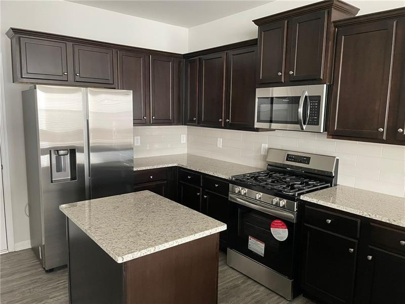 92 Shelter Lane East Dawsonville, GA 30534 - Photo 7 of 19 a kitchen with granite countertop a refrigerator stove and cabinets