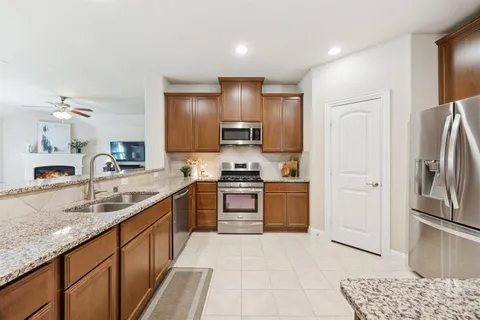 a kitchen with stainless steel appliances granite countertop a refrigerator and a sink