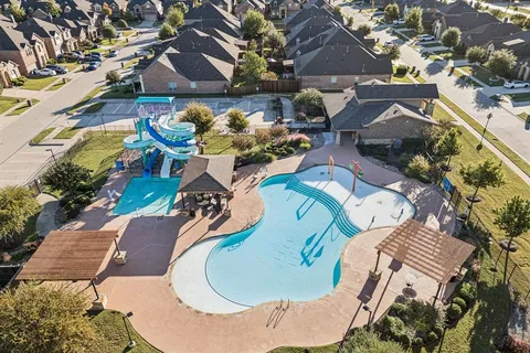 a view of a park with a table and chairs under an umbrella