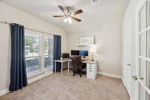 a view of a workspace with furniture and a window