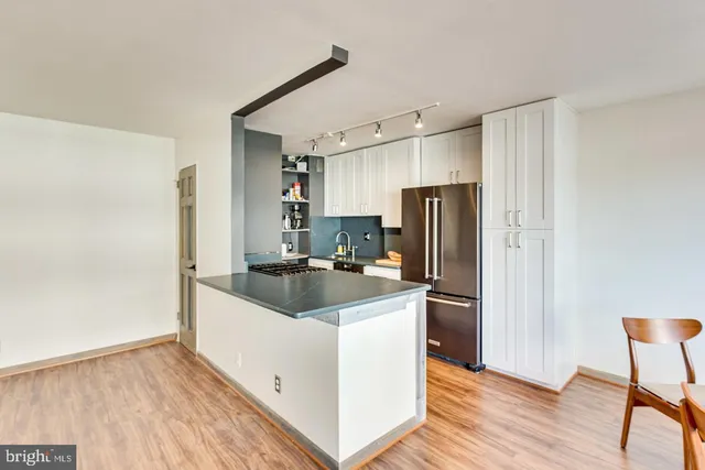 a kitchen with stainless steel appliances granite countertop a refrigerator and a stove top oven