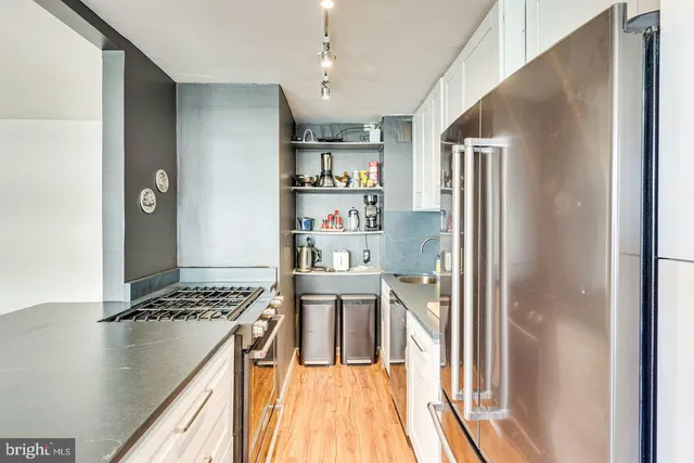 a kitchen with stainless steel appliances granite countertop a refrigerator and a stove