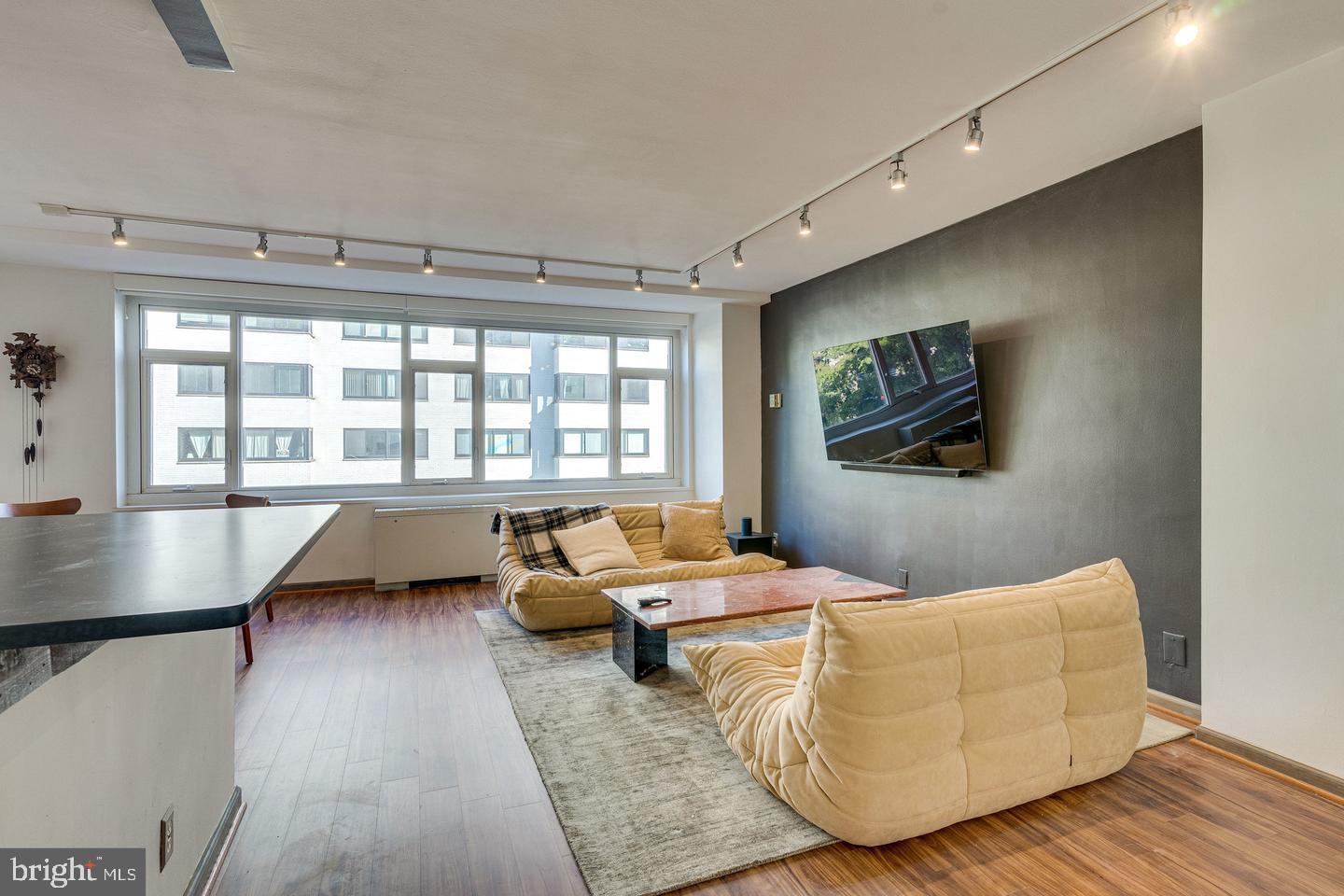 1545 18th Street Northwest, Unit 403 Washington, DC 20036 - Photo 10 of 44 a living room with couches bookshelf and a flat screen tv