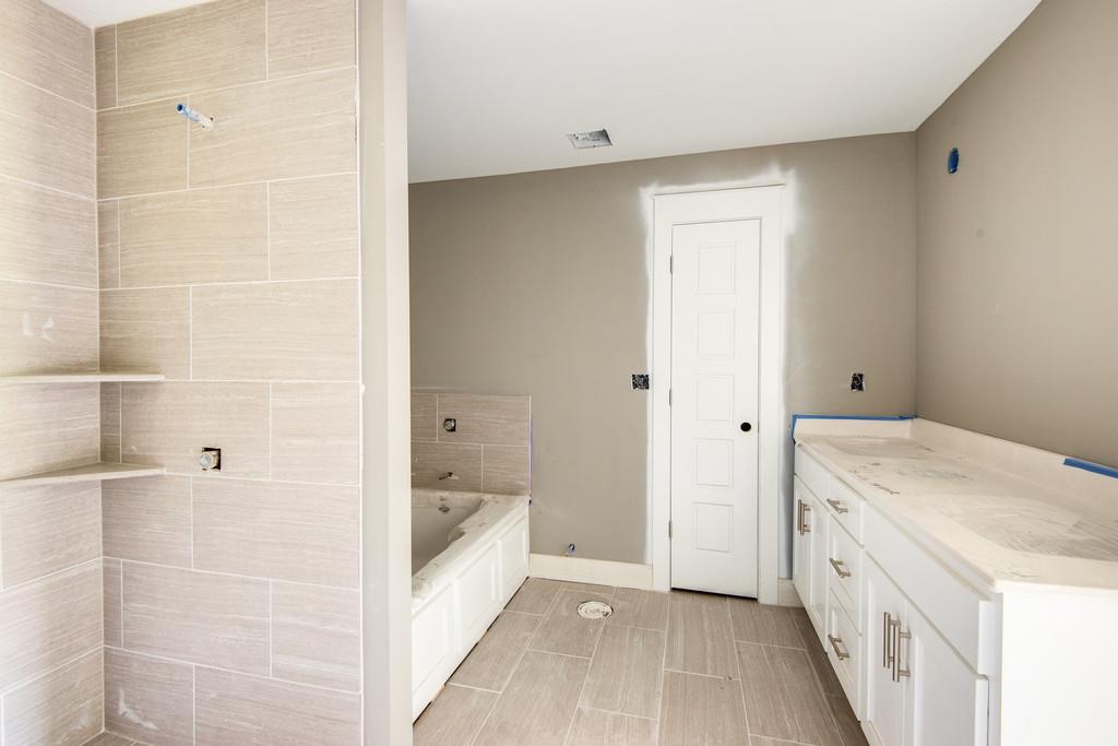807 Blakemore Road Dickson, TN 37055 - Photo 15 of 26 a bathroom with a granite countertop sink a mirror and a bathtub