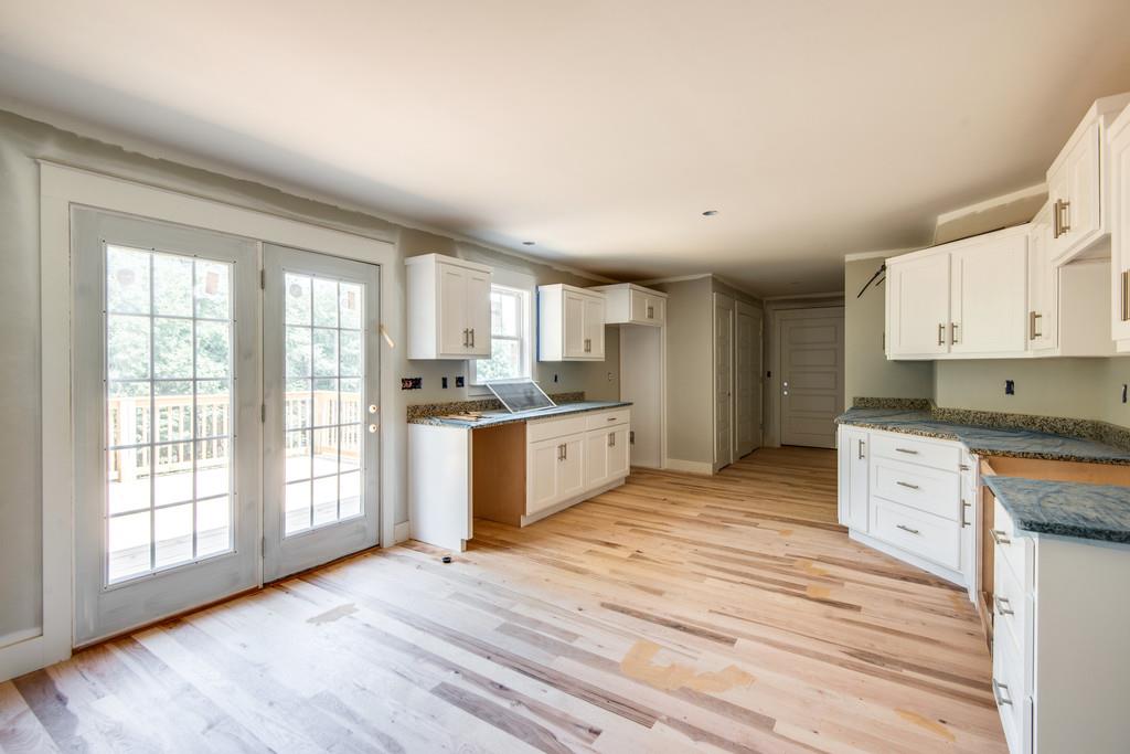 807 Blakemore Road Dickson, TN 37055 - Photo 6 of 26 a large kitchen with stainless steel appliances granite countertop a stove a sink dishwasher and white cabinets with wooden floor