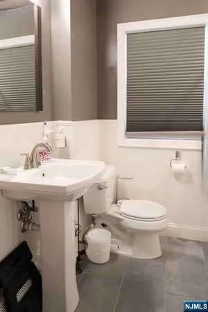 a bathroom with a sink a toilet and mirror