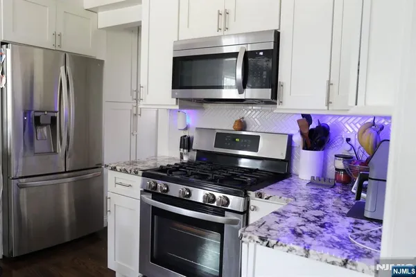 a kitchen with stainless steel appliances granite countertop a stove microwave and refrigerator