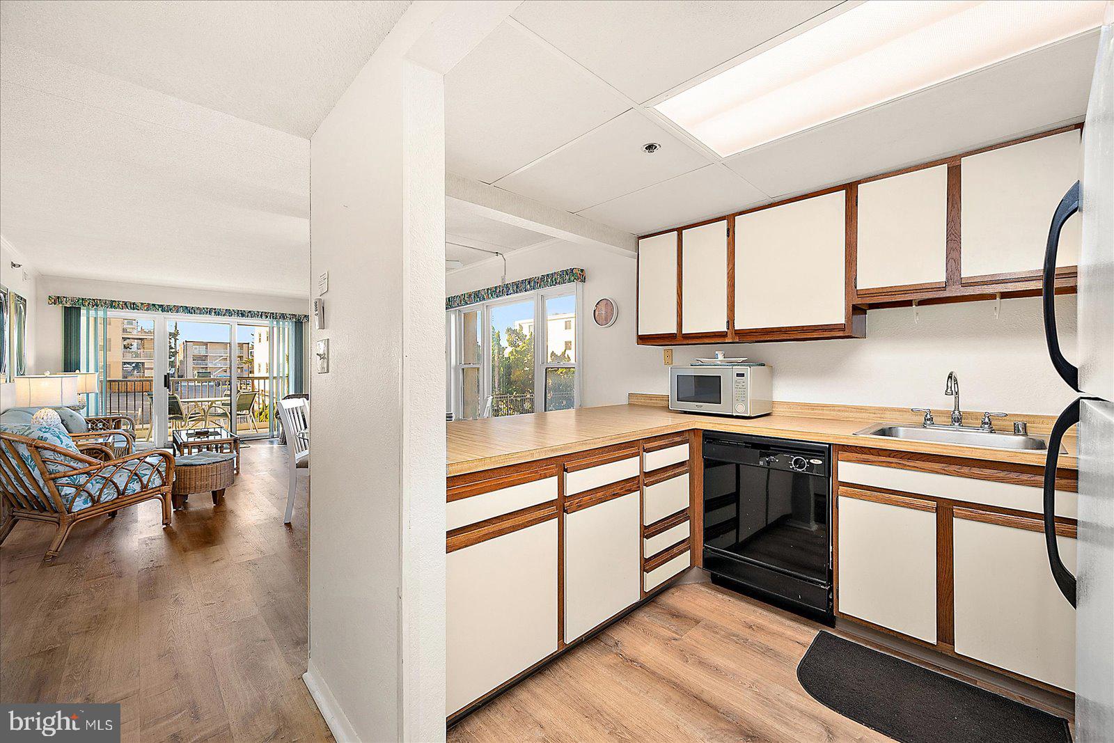 5801 Atlantic Avenue, Unit 101 Ocean City, MD 21842 - Photo 11 of 50 a kitchen with sink cabinets and wooden floor
