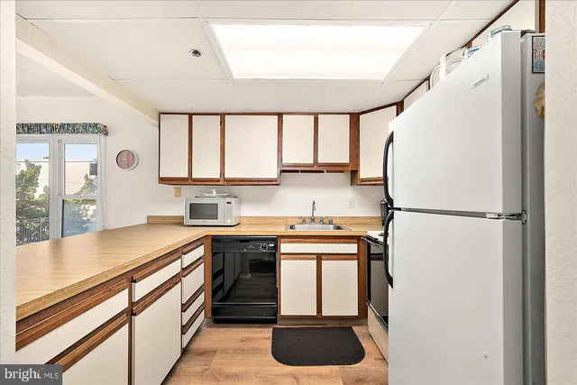 a kitchen with stainless steel appliances a refrigerator sink and cabinets