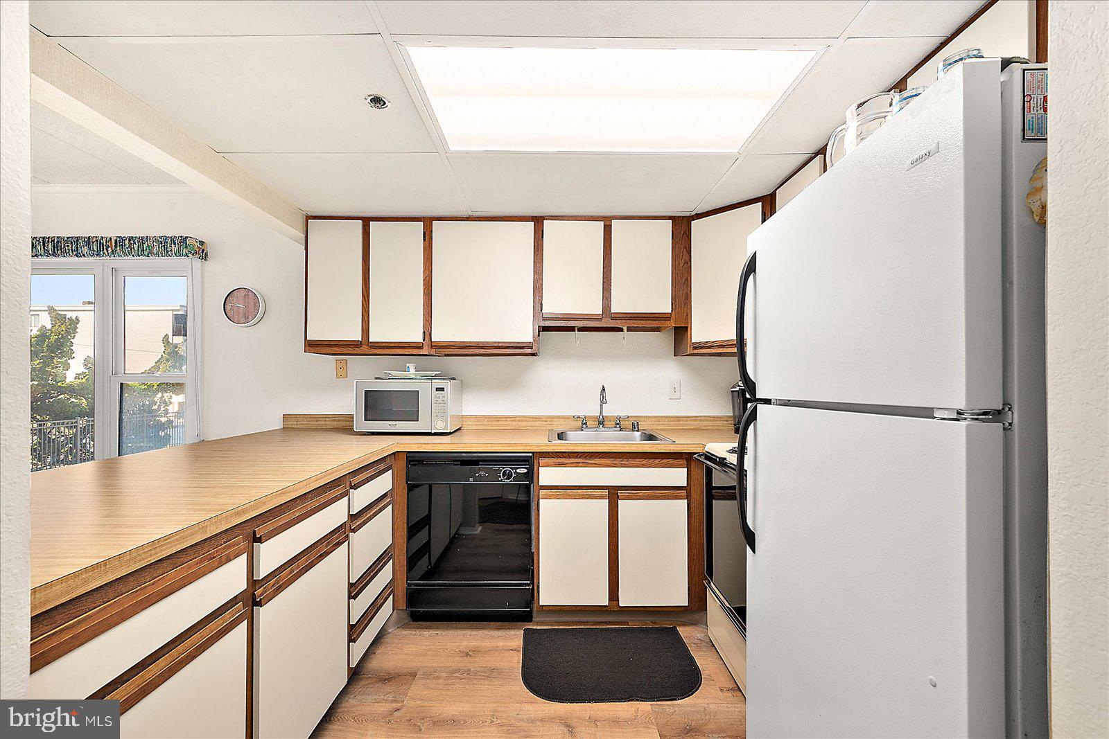5801 Atlantic Avenue, Unit 101 Ocean City, MD 21842 - Photo 12 of 50 a kitchen with stainless steel appliances a refrigerator sink and cabinets
