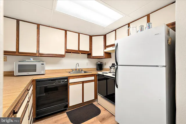 a kitchen with stainless steel appliances a refrigerator sink and cabinets