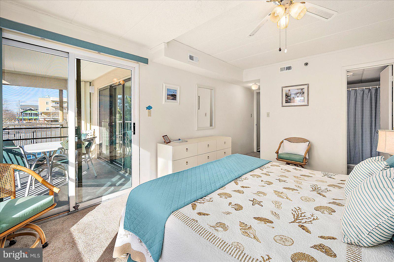 5801 Atlantic Avenue, Unit 101 Ocean City, MD 21842 - Photo 21 of 50 a bedroom with a bed and a chandelier