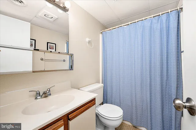 a bedroom with two beds and a lamp on the dresser