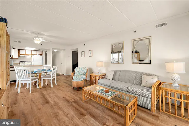 a living room with furniture wooden floor and a dining table