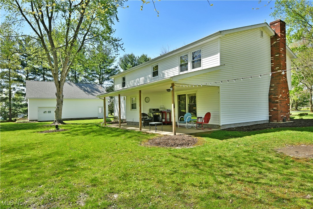 379 Housel Craft Road Bristolville, OH 44402 - Photo 6 of 50 Back of house featuring a patio, a lawn, and a chimney