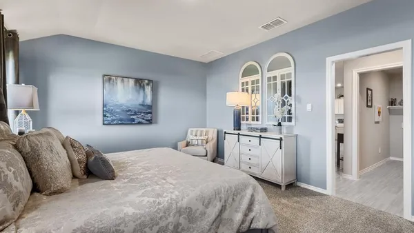 a bedroom with a bed and a chandelier