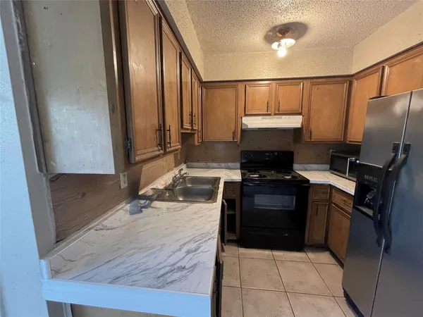 a kitchen with a refrigerator and a stove
