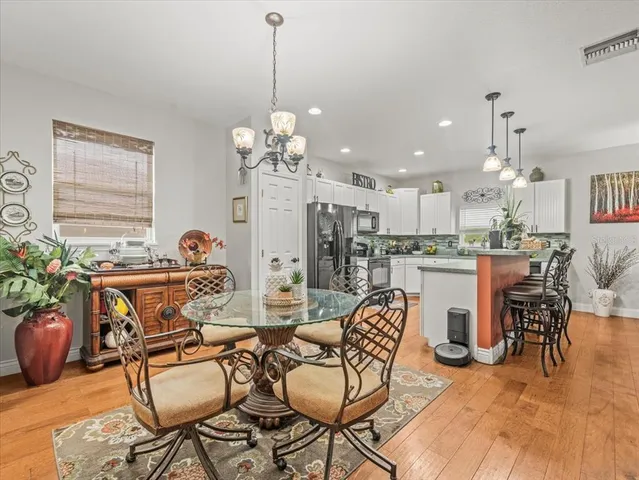 a view of a dining room with furniture a chandelier and wooden floor