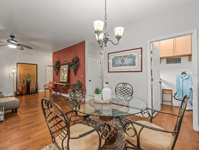 a kitchen with stainless steel appliances kitchen island granite countertop a dining table chairs and white cabinets