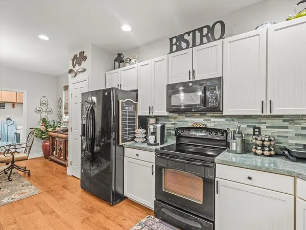 a kitchen with granite countertop a sink a stove and cabinets