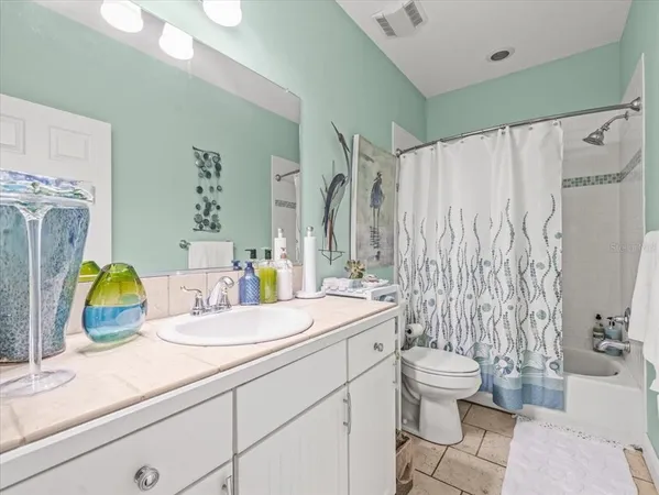 a bathroom with a granite countertop toilet sink and mirror