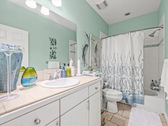 a bathroom with a granite countertop toilet sink and mirror