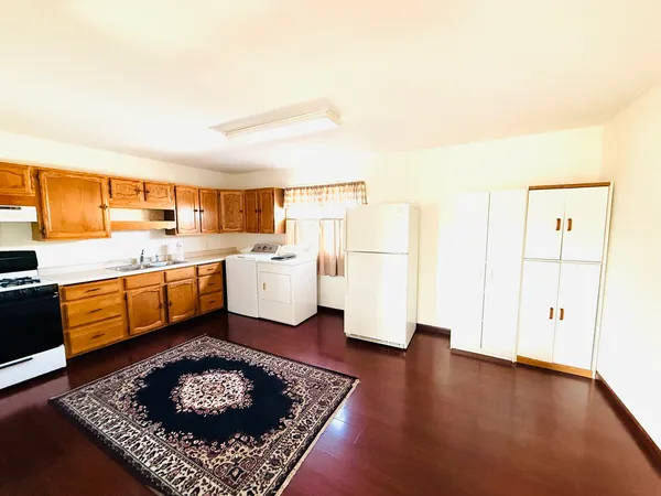 a kitchen with stainless steel appliances granite countertop a refrigerator sink and white cabinets