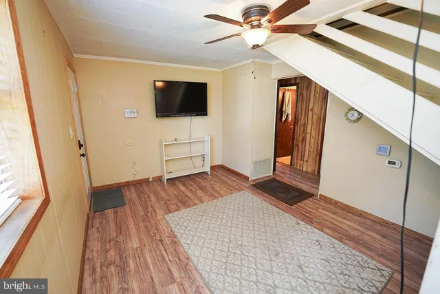 a view of a livingroom with wooden floor and staircase