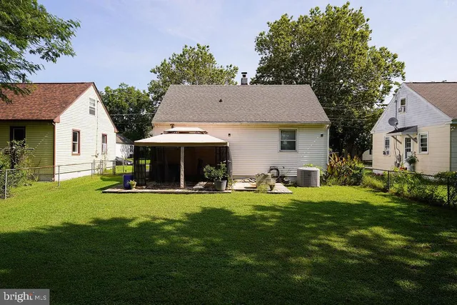 a view of a house with a yard fire pit and chairs