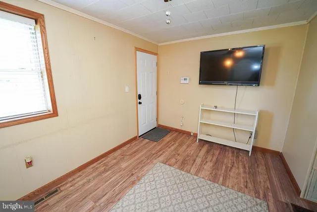 a view of a livingroom with wooden floor and a flat screen tv