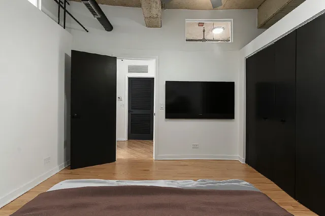 a bedroom with a bed a chandelier and a window