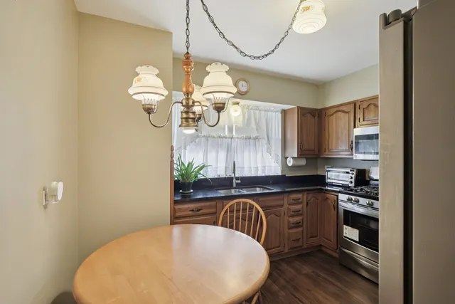 a kitchen with a table chairs and a chandelier