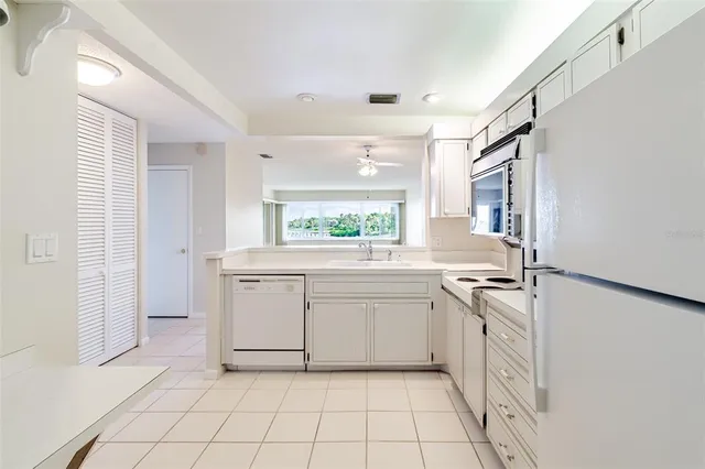 a view of a kitchen with white cabinets